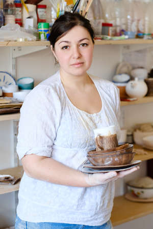 handmade hobby pottery courses. master class at workshop. potter holding craft clay crockeryの写真素材