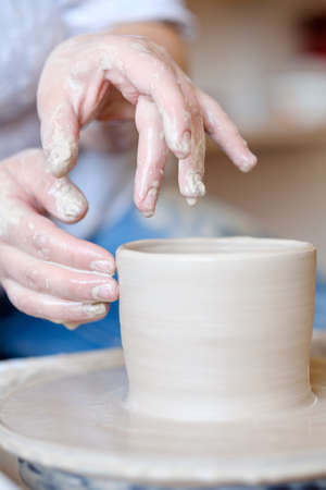 handmade hobby pottery courses. master class at workshop. potter forming clay on turning wheelの写真素材