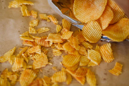crispy crunchy potato chips are a great party munchies. delicious food snack. waved rudged fried slices scattered on the surfaceの写真素材