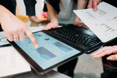 business paperwork. data analysis, marketing statistics research. office workers study documents with graphs and charts on laptopの写真素材