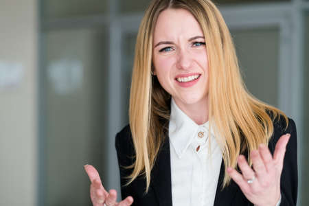 emotion face unbelievable. astonished dumbfounded bewildered astounded shocked perplexed woman. business lady at office workspace. young beautiful blond girl portraitの写真素材