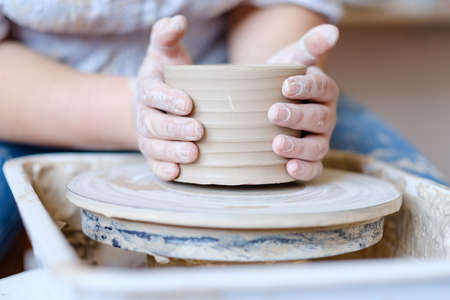 pottery workshop. handmade craft. artisan forming and shaping clay on potter wheelの写真素材