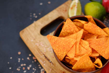 homemade fried tortilla nacho chips. spicy crisps in a bowl on dark background. delicious salty food snackの写真素材