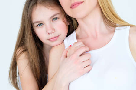 family love and bond. mom and daughter close relationship. little girl hugging her mother.の写真素材