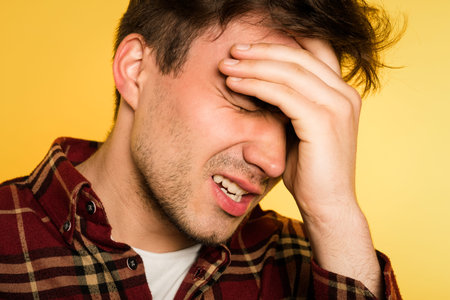 headache or migraine. man in pain clutching his head. discomfort ache and misery. portrait of a...