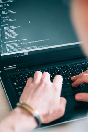 Programmer writing code on his laptop. web developer designing application. internet technologies conceptの写真素材