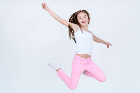 Child jumping high in the air. airiness lightness freedom happiness and carefree childhood emotion concept. little girl on white backgroundの写真素材