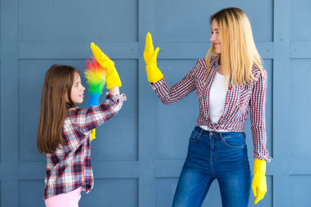 family teamwork. home cleaning and household chores. mom and kid daughter giving high five.