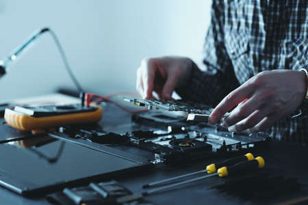 computer upgrade. technology development. microelectronics scientific innovation concept. engineer disassembling laptopの写真素材