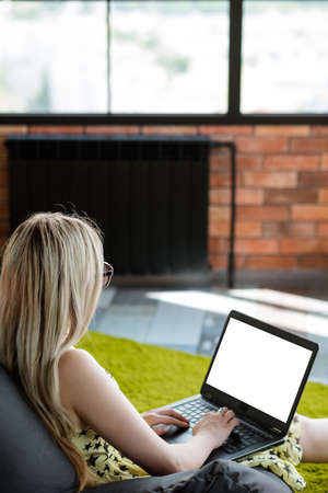virtual assistant. freelance job. remote work to earn money online. comfortable workspace at home. relaxed woman typing on laptop.の写真素材