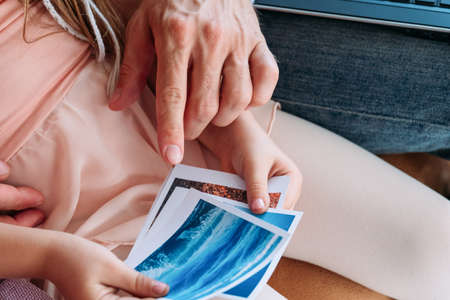 travel memories. dad and child looking through the photos of their summer vacation on the seaside. tourism holiday voyage and trips concept.の写真素材