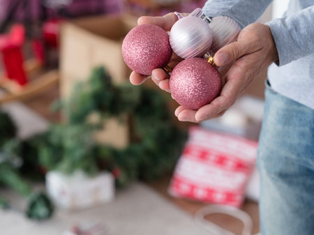 christmas festive decoration balls. new year holiday ornaments concept. man holding handful of rose...