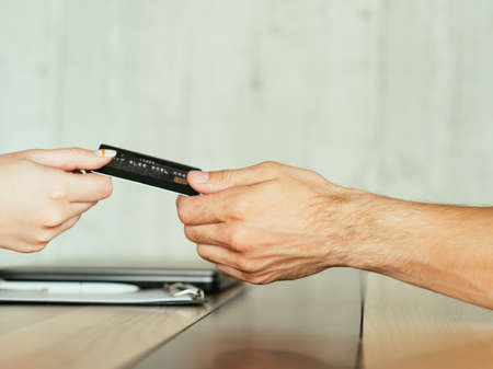 online investment. making money on the internet. electronic financial operations. two people holding credit or debit bank card.の写真素材