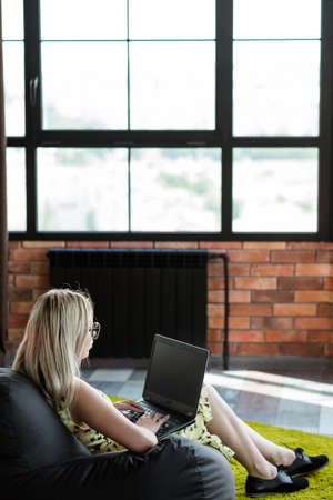 freelance work or remote job. self-employed woman working on laptop. relaxed and comfortable workspace at home.の写真素材