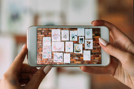 artist blogger. creative drawing and blogging. painter takes mobile photo of her works to post onlineの写真素材