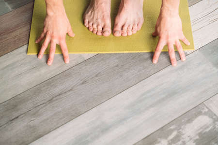 yoga training. sport and fitness. wellness lifestyle and regular gym workout. male feet and hands on a yoga mat preparing to exercise. copyspace concept.の写真素材
