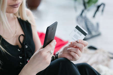 online shopping. convenient modern technology. mobile payments and easy goods purchase concept. woman holding smartphone and credit card in hands.の写真素材
