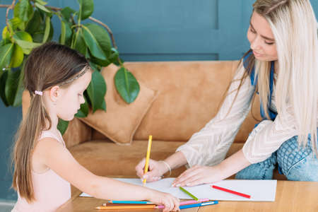 family leisure. creative and artful mother and daughter drawing together. loving relationship and responsible parenting.の写真素材