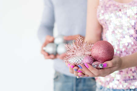 family christmas home decoration traditions. woman holding handful of rose gold glittery balls and snowflake. holiday festive ornament concept.の写真素材