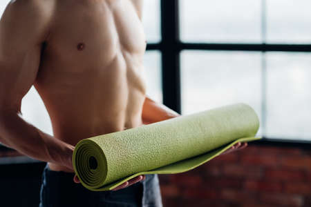 sport fitness and gym training. taking care of your body health. man holding yoga mat prepared to exercise.の写真素材