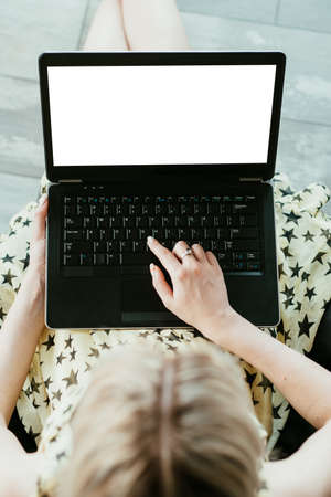 blogger blogging and social media concept. woman working at home writing new post. empty white laptop screen for advertising.の写真素材