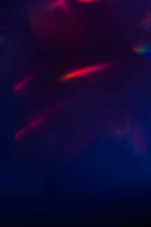 abstract lens flare on dark blue background. red defocused lights. glowing blurred color burst. festive new year backdrop.の写真素材