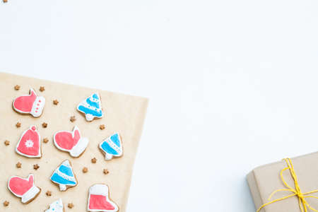 festive season background. handmade gingerbread christmas cookies and packaged gift on white backdrop with copyspace.の写真素材