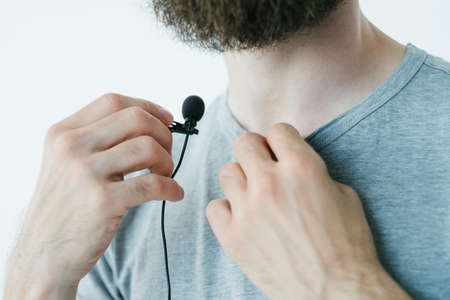 blogger preparing for video streaming.   man putting microphone on for quality sound. professional equipment concept.の写真素材