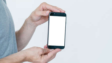 mobile payment. money transaction and orders. financial operations on the internet using digital devices. man holding smart phone with empty white screen on white background.の写真素材