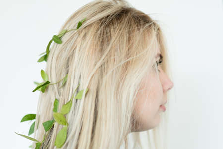 harmony with nature. eco friendly sustainable lifestyle. natural hair products. blond girl wearing flowers in her updo.の写真素材