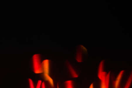 abstract lens flare on black background. red defocused bokeh lights. blurred christmas wallpaper decor. festive glowing circles design.の写真素材