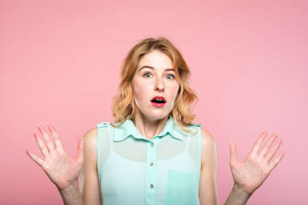 emotion expression. overwhelmed shocked surprised astounded woman gasping from amazement. young beautiful girl portrait on pink background.の写真素材