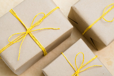 handmade craft presents. paper wrapped gifts with yellow twine bows. assortment of festive packages on light background.の写真素材