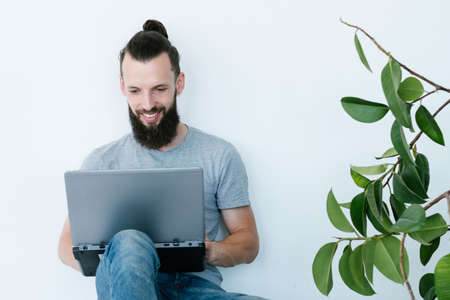 online business. man working from home. making money on the internet. young bearded hipster holding laptop. freelance job and remote work concept.の写真素材