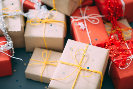 party presents selection. mix of gift boxes wrapped in craft and red paper decorated with bead...