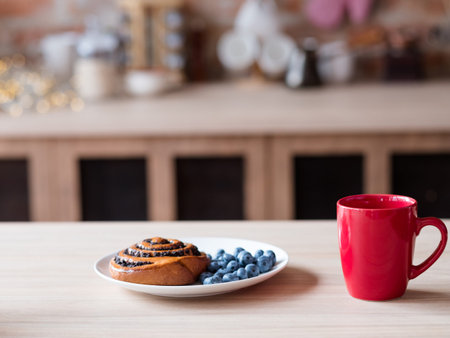 healthy food and quick breakfast. morning meal. poppy seed bun fresh blueberry and tea or coffee in...