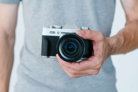 modern technology for photo and video content creation. unrecognizable man holding camera in hands. blogger equipment and tools concept.の写真素材