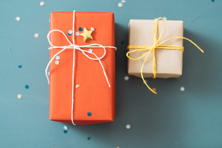 couple gifts for anniversary or valentine day. two present boxes wrapped in red and craft paper and...