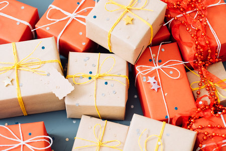 party gifts assortment. mix of present boxes wrapped in craft and red paper decorated with bead...
