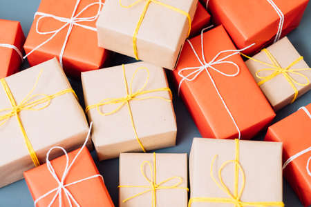 festive christmas holiday background. mix of presents in gift boxes wrapped in red and craft paper.の写真素材