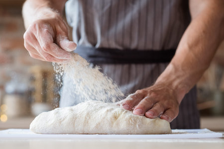 food cooking concept. chef preparing homemade bread or puff pastry. man hands kneading dough and...