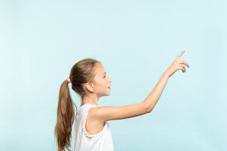 thoughtful girl reaching and wanting to press invisible button on the right. interface or virtual...