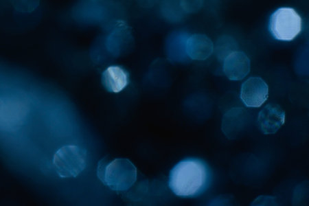 abstract lens flare on black background. blue defocused bokeh lights. glowing color burst. festive...