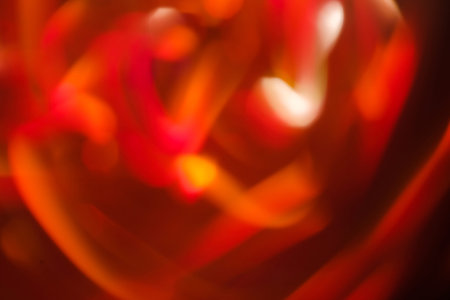 abstract lens flare on black background. red defocused bokeh blurred swirl. new year fireworks wallpaper design.の写真素材
