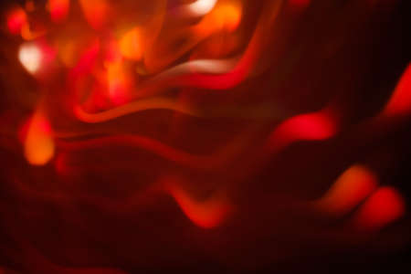 abstract lens flare on black background. red defocused bokeh lights. blurred wavy christmas wallpaper decor. festive glowing firework sparks design.の写真素材