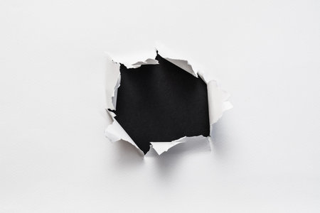 ripped torn white paper showing empty black space. minimalistic background for advertising or text...