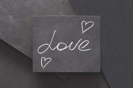 love and hearts. romance happiness and emotion. message handwritten on black layered paper background.の写真素材