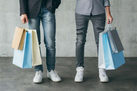 shopping and store sale. midsection of couple with multiple bags in hands.の写真素材