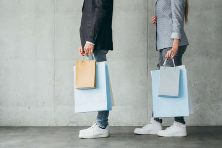 shopping lifestyle and buying addiction. midsection of man and woman holding multiple bags in hands.の写真素材
