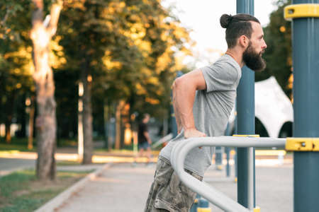 workout and outdoor training. man doing parallel bar dips. fitness and healthy lifestyle.